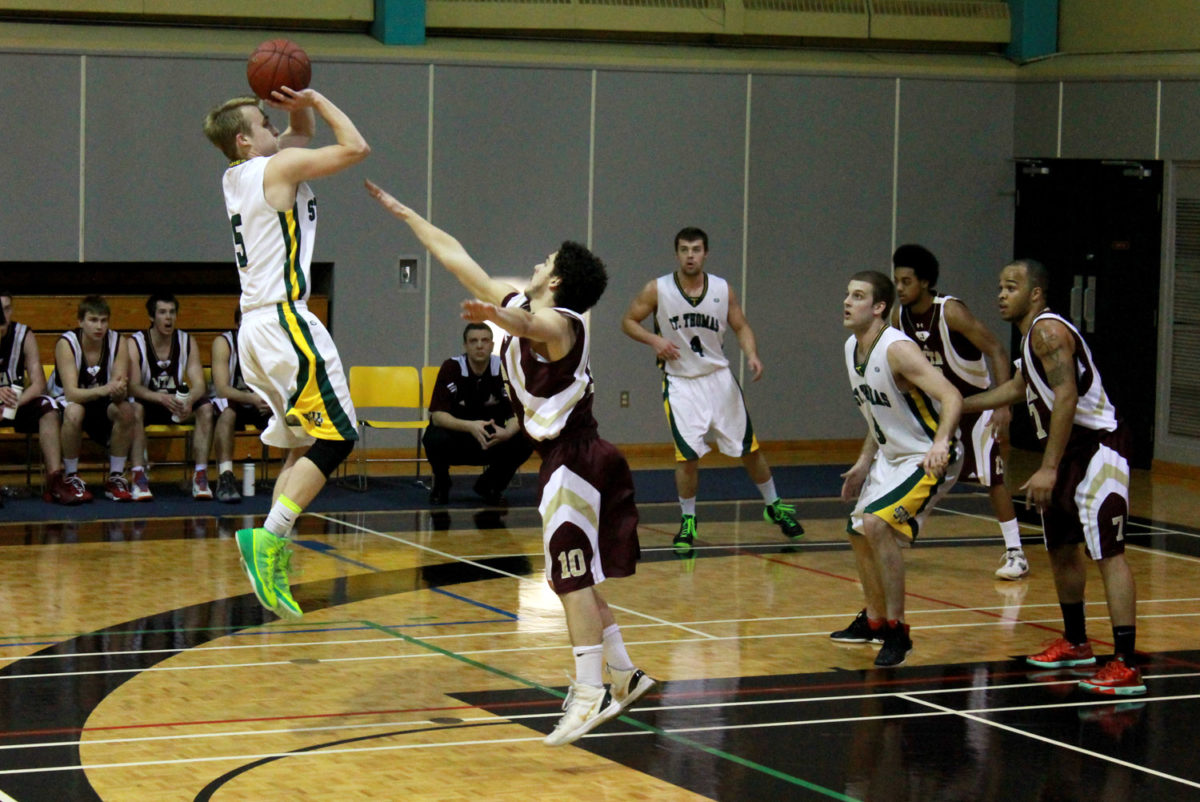 Nathan Mazurkiewicz (left) rises above a Mt. Allison defender in ACAA playoffs in February (Philip Drost/AQ)