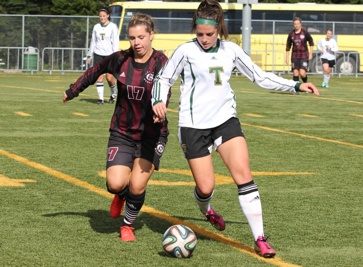 Jory Donovan, left, of the Holland College Hurricanes is held off by Zoé de Bellefeuille of the St. Thomas Tommies in Saturday's women's soccer game at Scotiabank Park South. Photo: Chris Robinson/The AQ