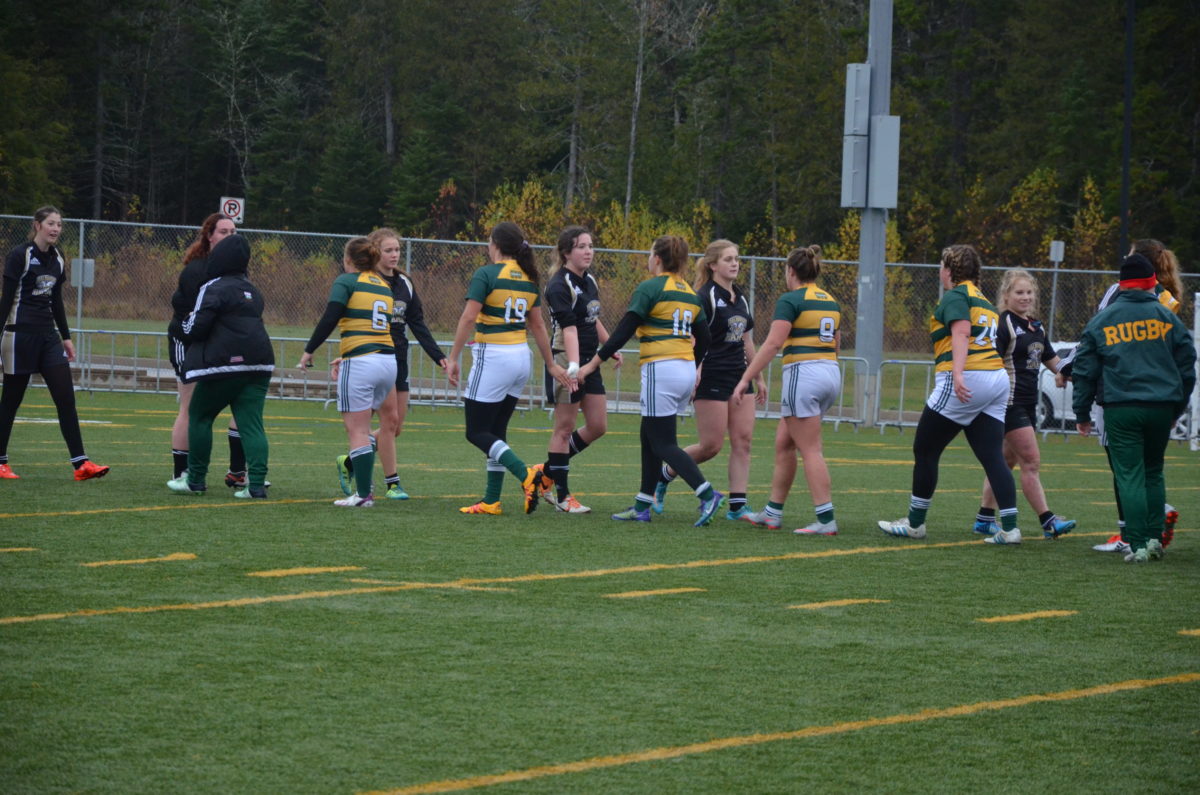Members of the Tommies women's rugby team, in stripes, and the Dalhousie Agricultural College Rams shake hands after the Tommies downed the Rams 57-0 in the Atlantic Collegiate Athletic Association semifinal Saturday at Scotiabank Park South. Photo: Nathan DeLong/The AQ