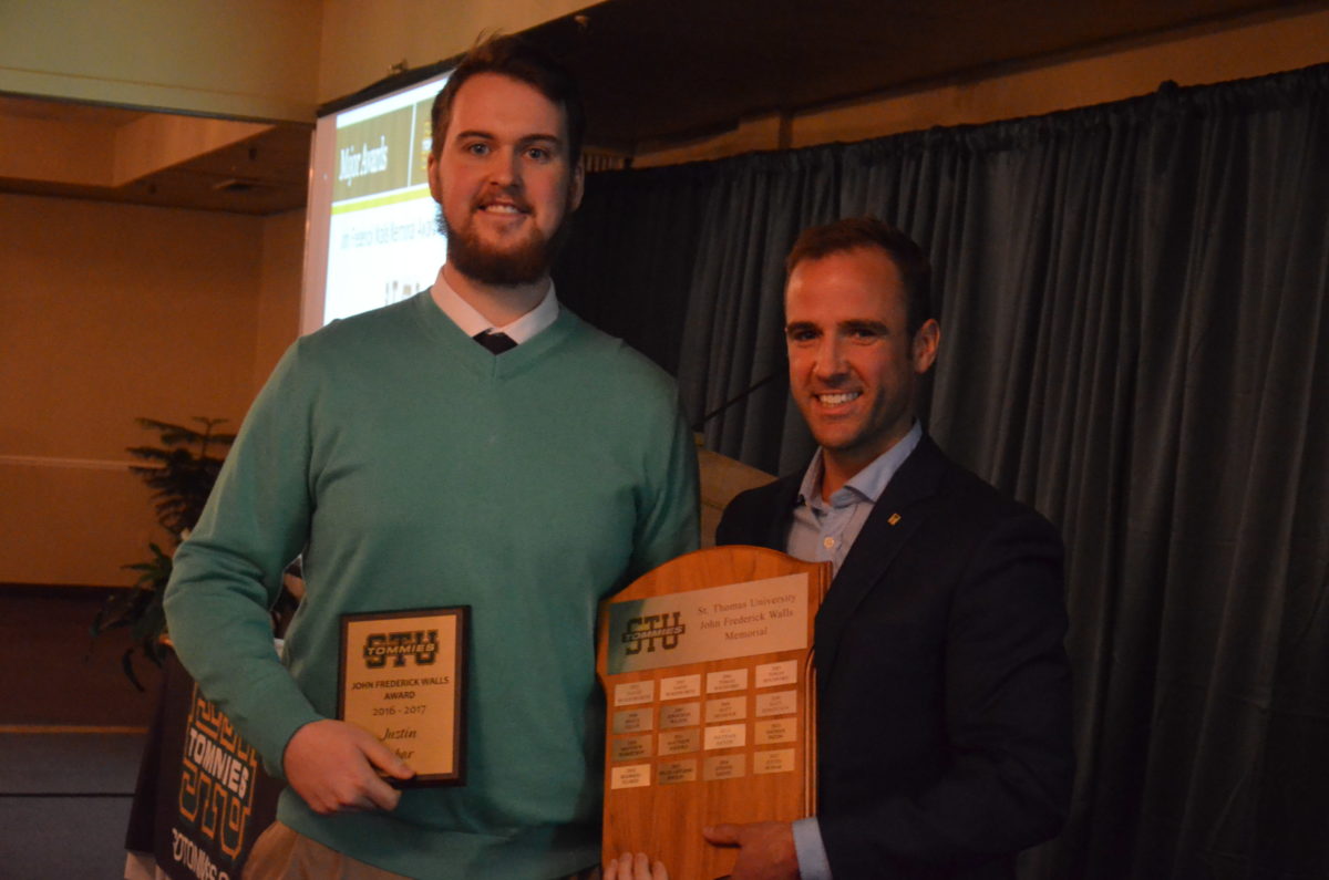 Men's rugby player Justin Robar, left, accepts the John Frederick Walls Memorial Award from Fredericton MP Matt DeCourcey. Photo: Nathan DeLong/The AQ